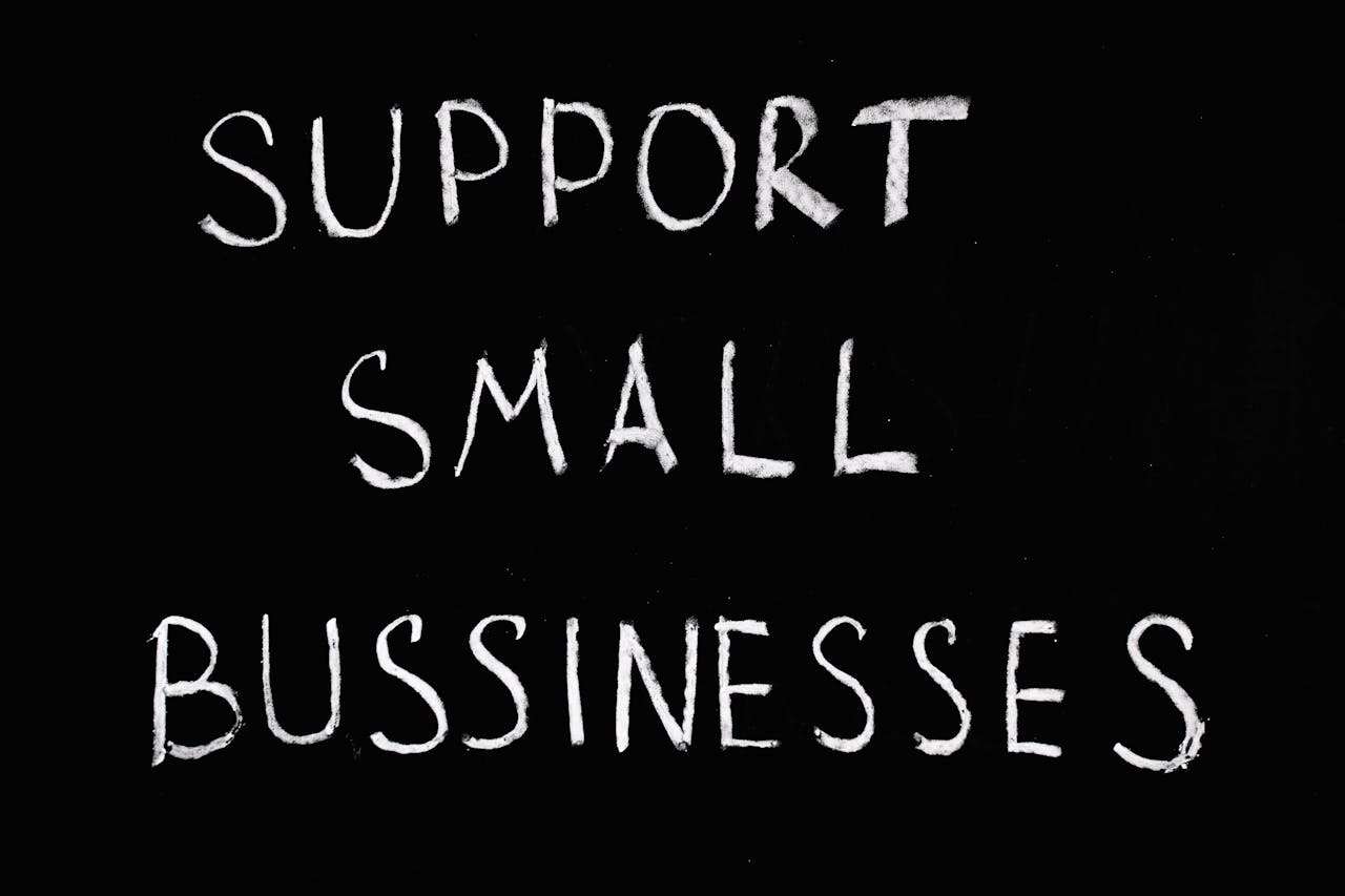 Inspirational chalkboard text 'Support Small Businesses' on black background.