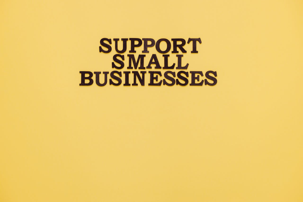 Inspirational image with 'Support Small Businesses' text on a warm yellow background.